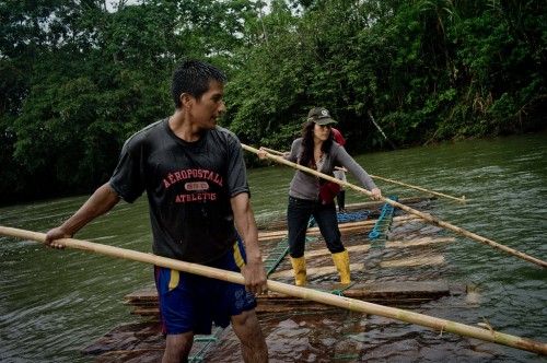 A cientista do CIFOR Elena Mejía, direita, acompanha habitantes quíchuas que estão transportando madeira ao longo do rio Arajuno, no Equador. Tomas Munita/ CIFOR