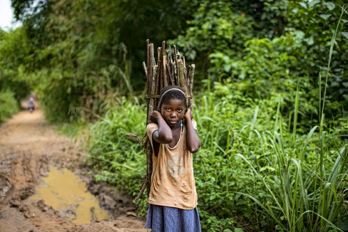 A child carries firewood while we were on the way from Kisangani to the village of Masako. Democratic Republic of Congo. Photo by Ollivier Girard for Center for International Forestry Research (CIFOR)
