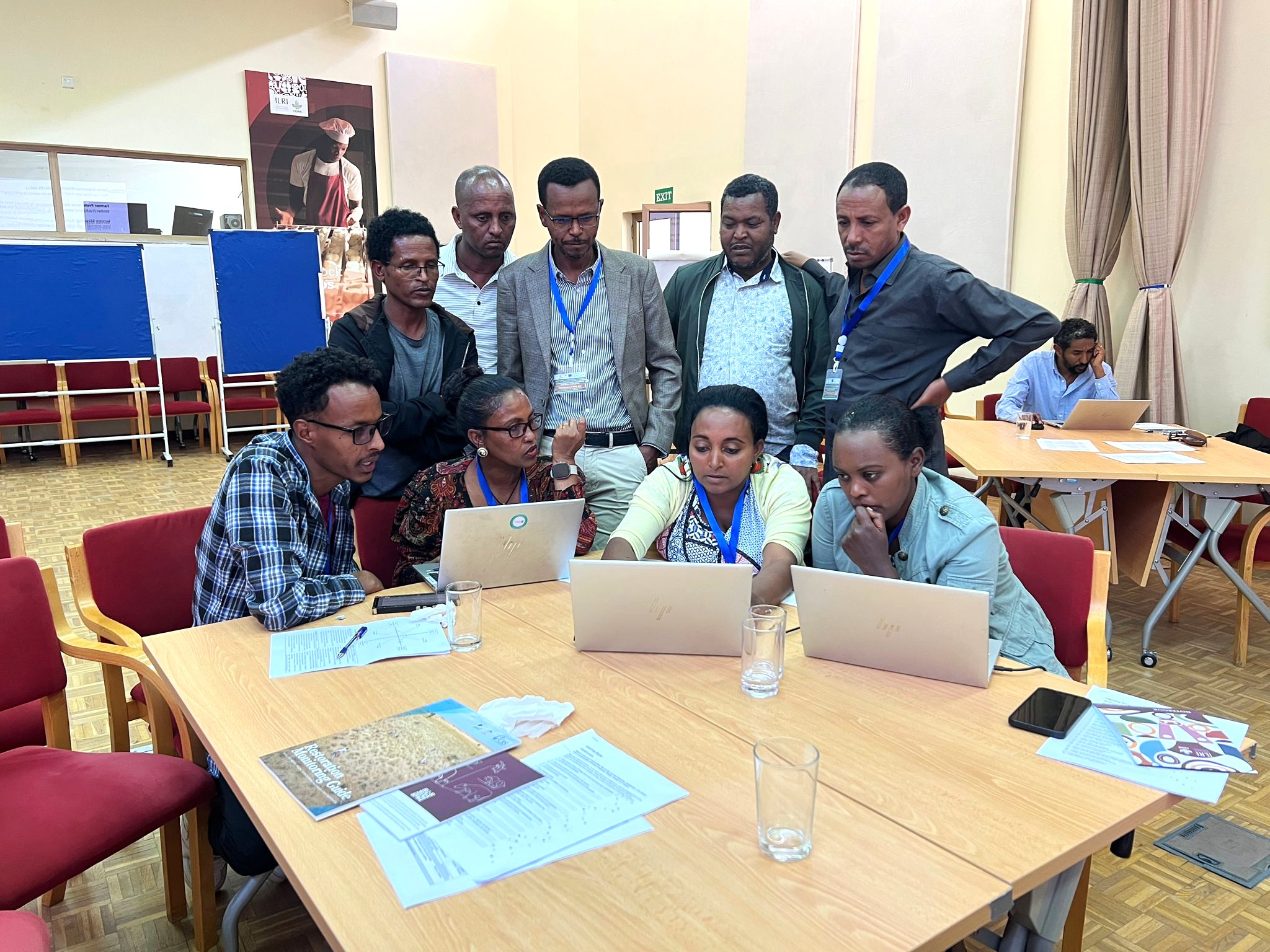 Training participants gathered around laptops during a group exercise on seed systems and nursery management.