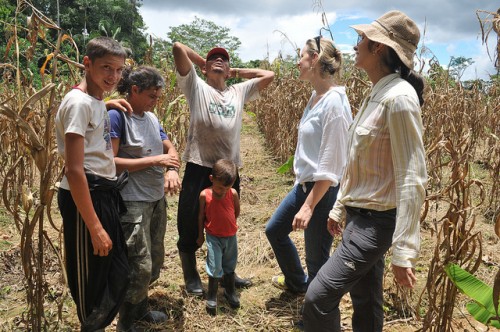 Kaline (direita) falando com família de agricultores no Acre — ficar com as famílias é um dos prazeres do trabalho de campo, diz ela. Kate Evans/CIFOR