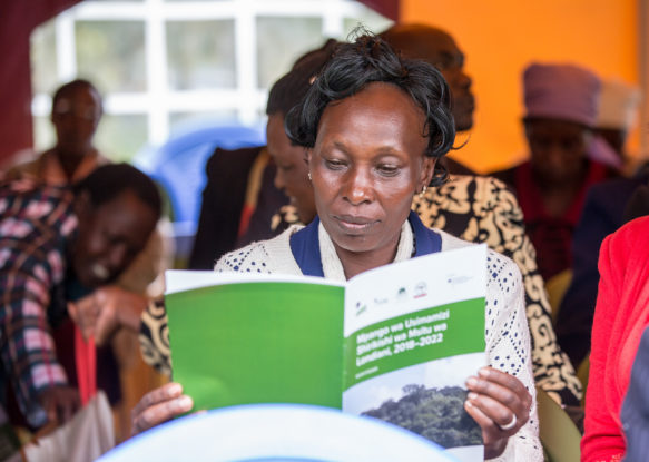 A lady Community member reads through the new integrated water and forestry plans