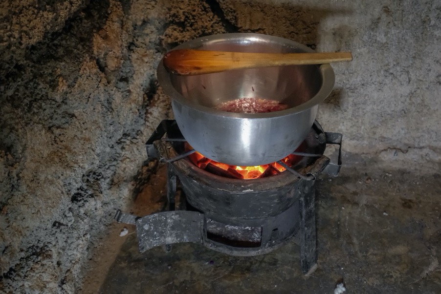 A pot sits on charcoal embers