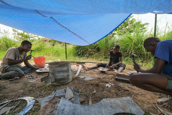 Men work on stove construction under under a tarpaulin
