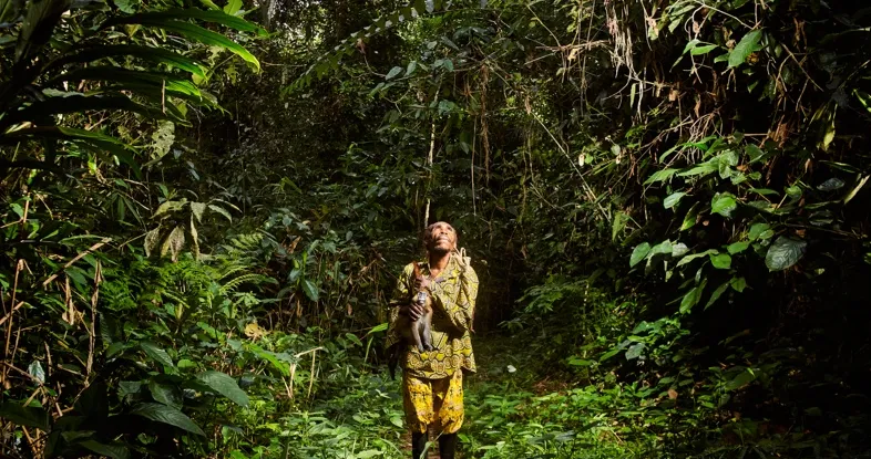 Un chasseur dans la forêt transporte son butin sur sa kinga. Photo : Vivian Anogo / CIFOR-ICRAF