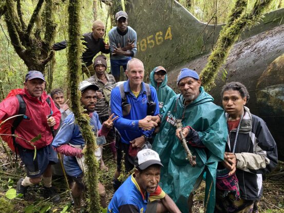 Peter Gamgee and local guides gathered beside the WWII Flying Dutchman wreck in Papua New Guinea’s Mount Obree cloud forest during its 2024 rediscovery