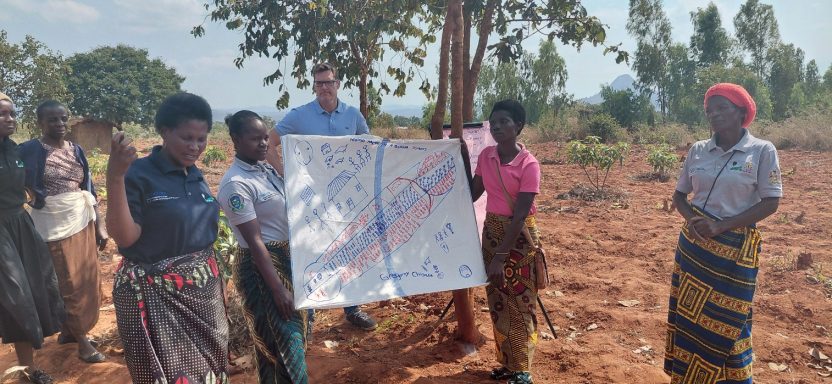 In Malawi, farmer Gregoria Chisale presents her farm management plan to a delegation, showing women empowerment and resilience in food tree value chains.
