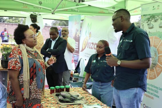 SWM Programme team members stand beside a table displaying honey and fish products