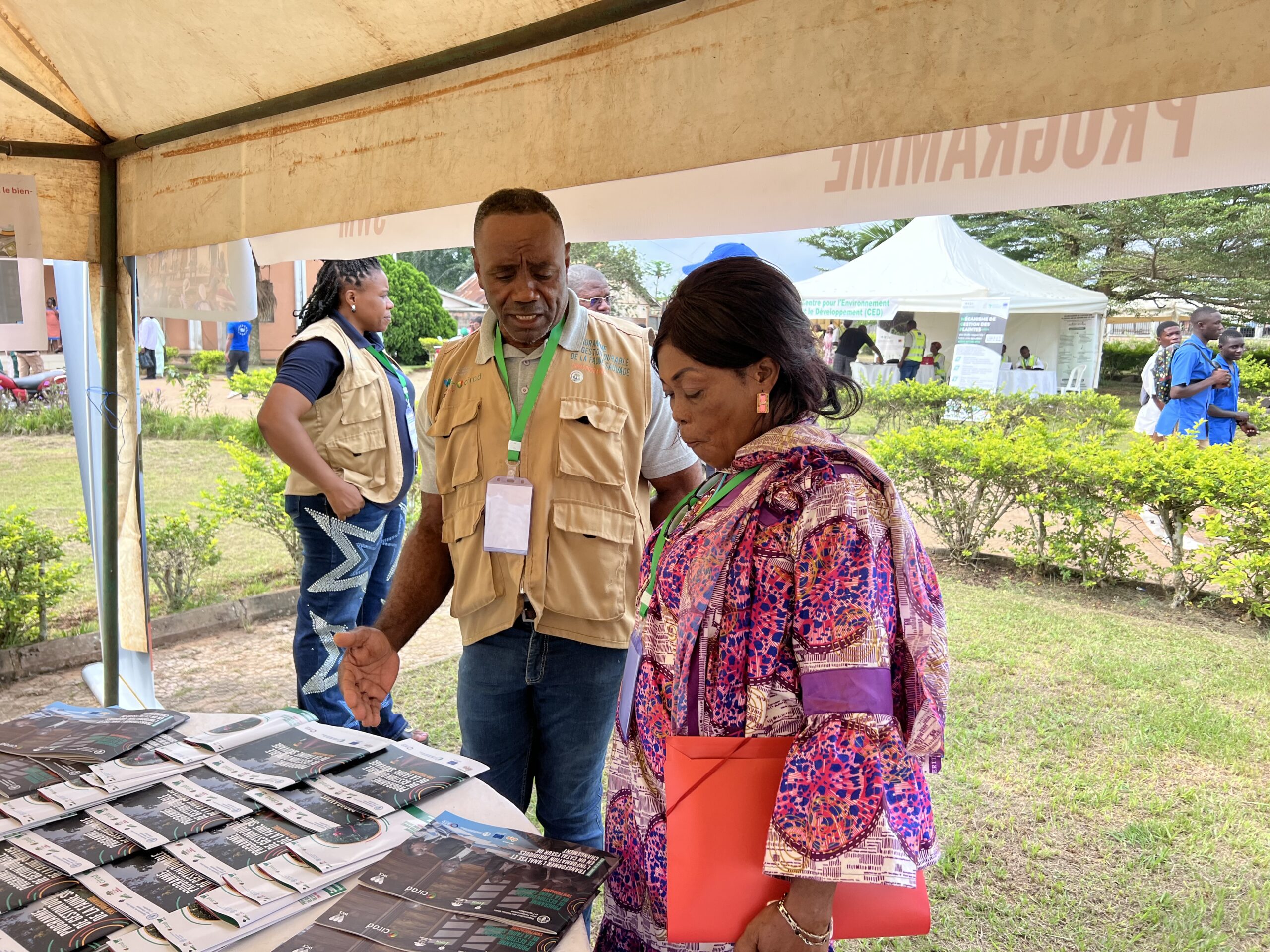 Robert Okale presents Sustainable Wildlife Management Programme materials to a visitor at an outreach event.