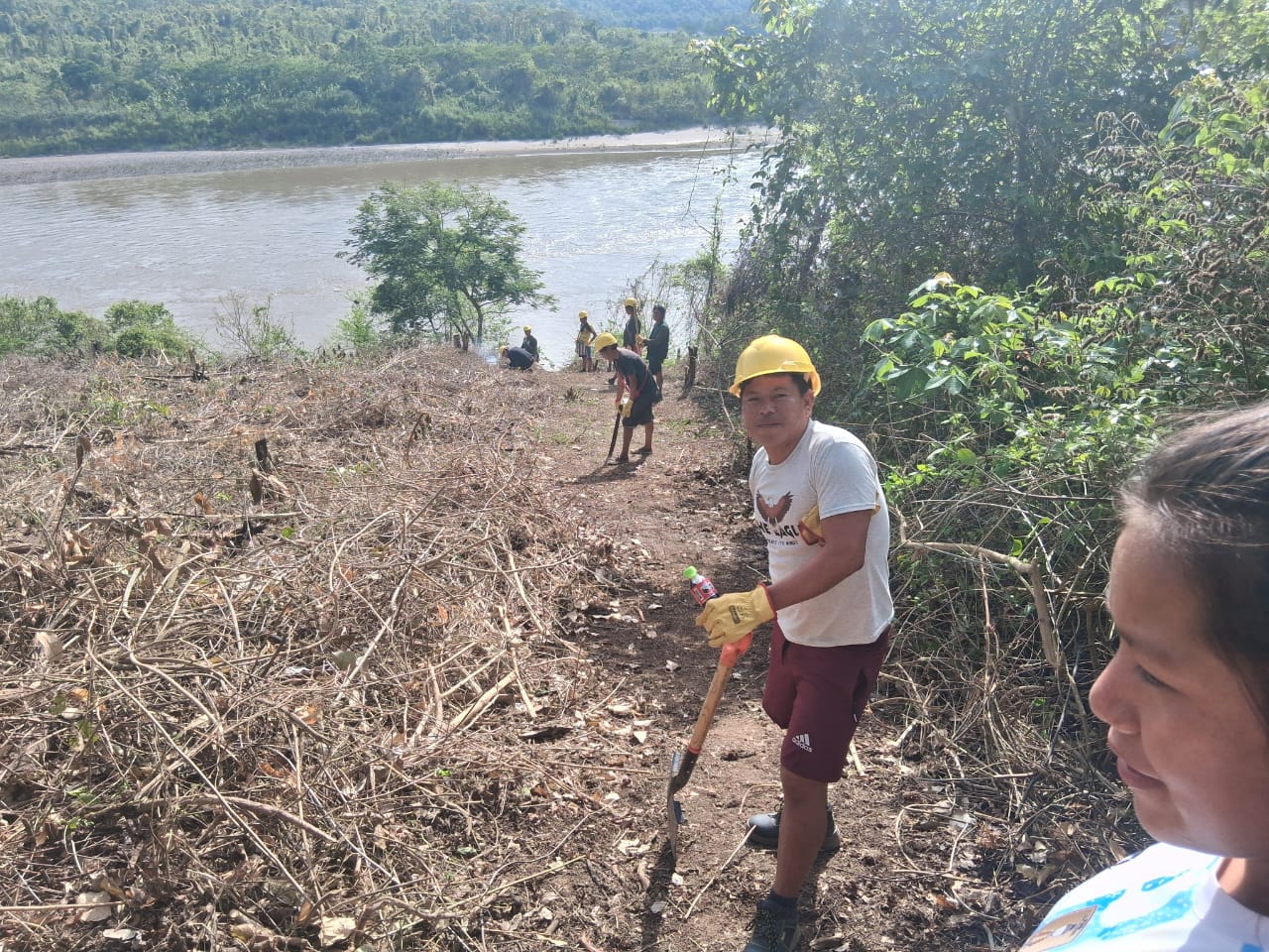 Brigade member Romer Quentimari helps clear a firebreak before a controlled agricultural burn near the Ene River.