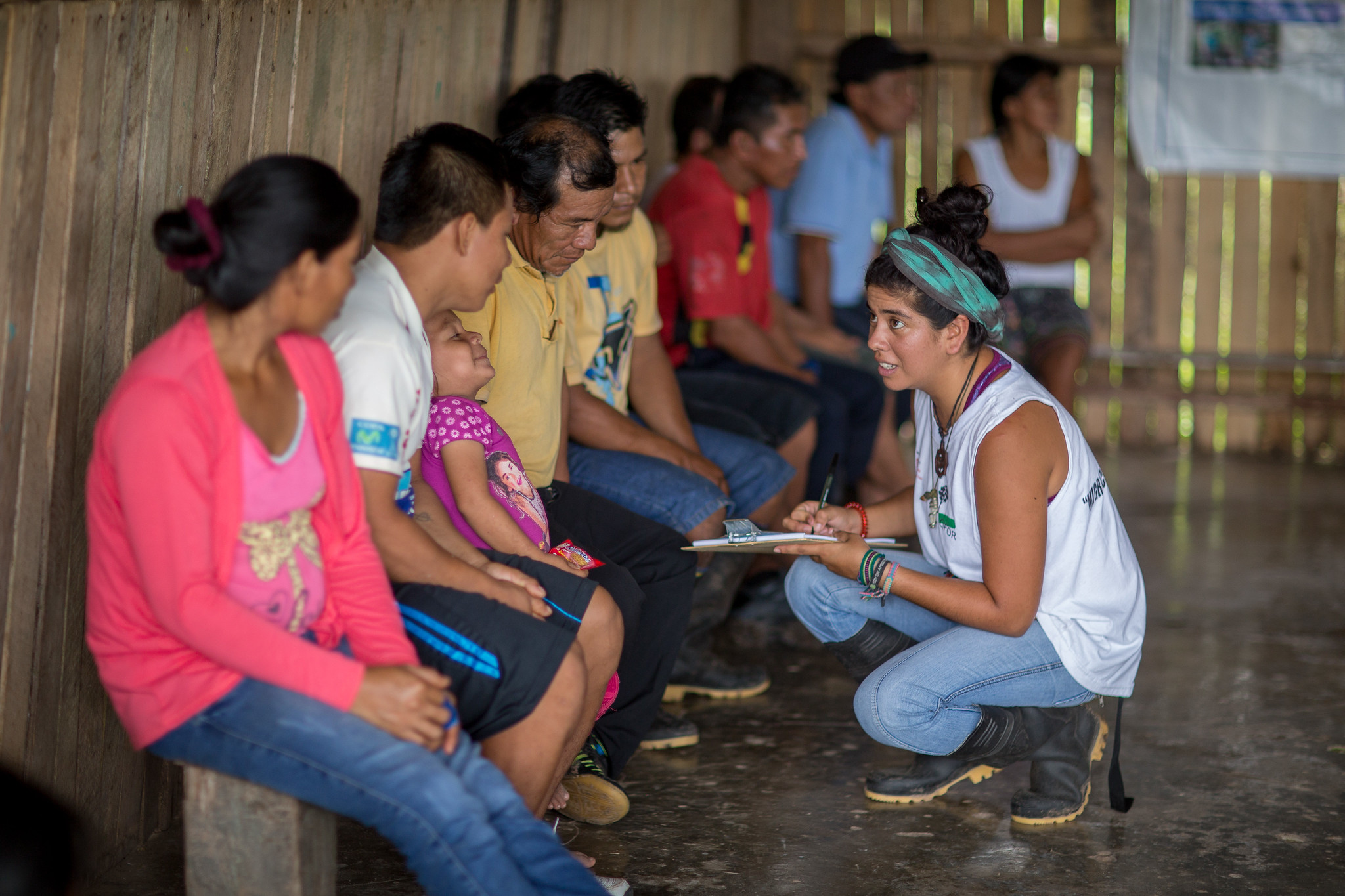 Community members speak with a CIFOR team member inside a wooden community building in Cashiboya, Loreto, Peru.
