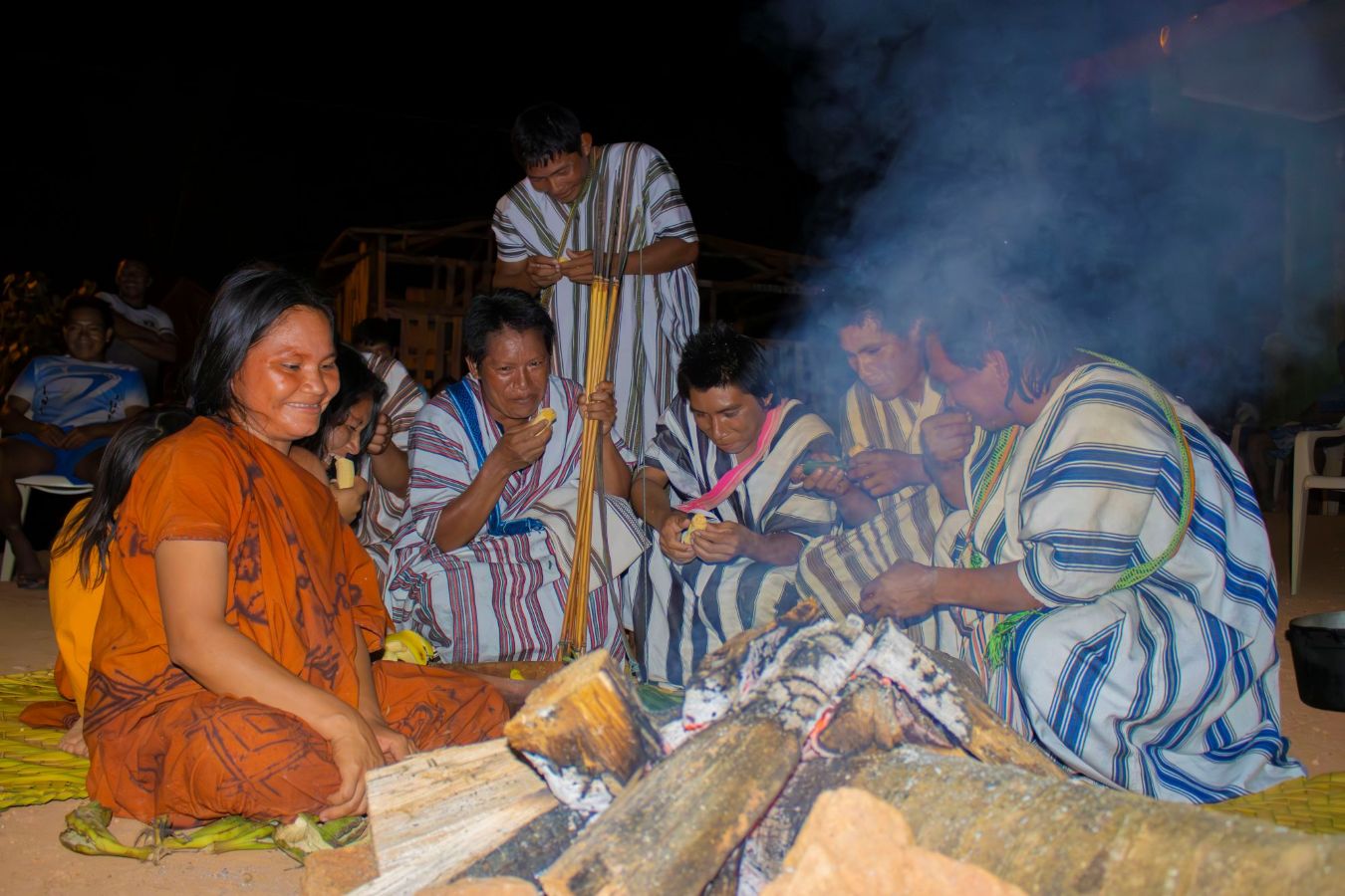 Asháninka families gather around a fire during a community meeting in the Peruvian Amazon.