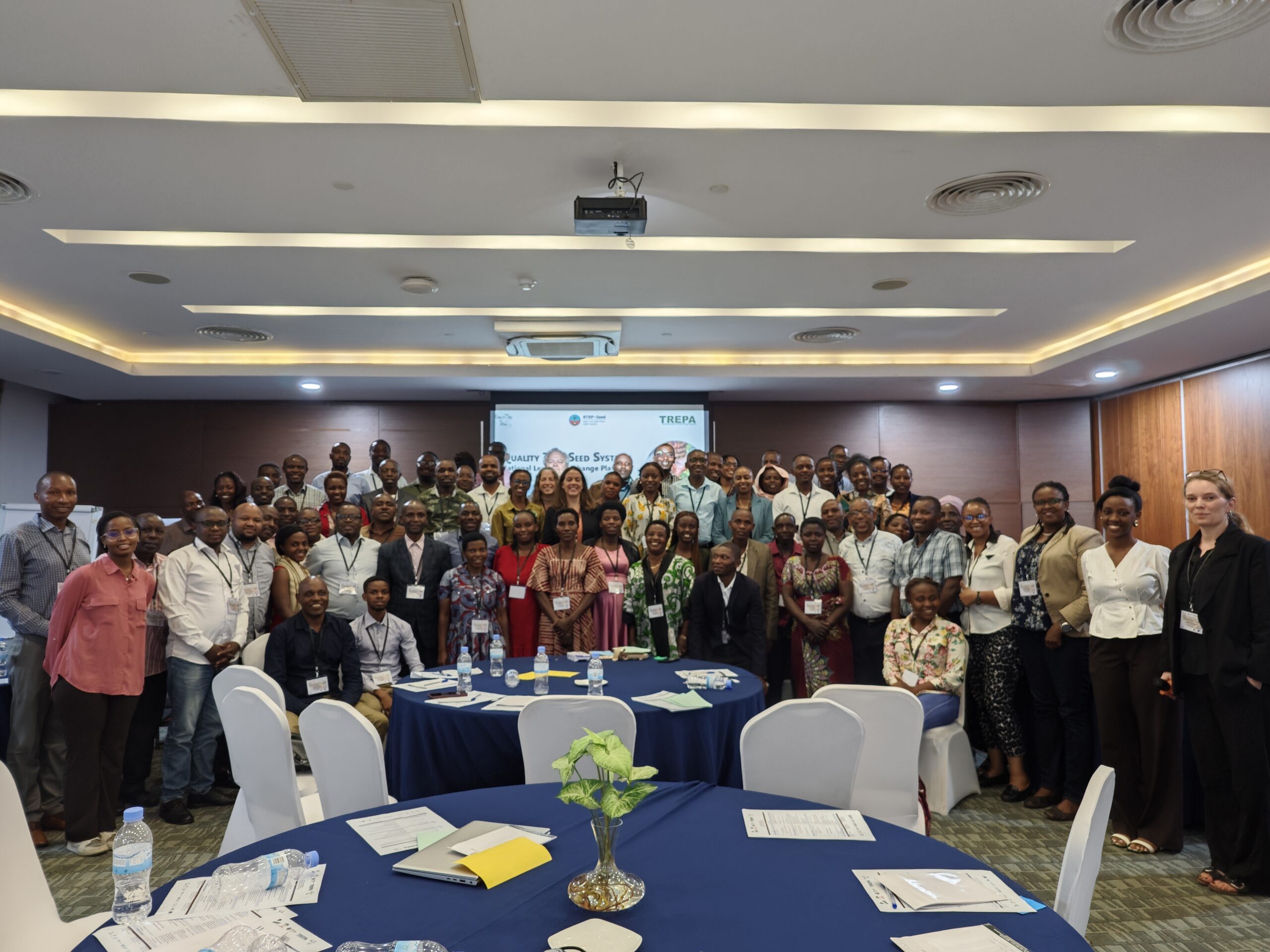 A large group of participants poses for a photograph in a conference room following a national learning exchange on tree seed systems.