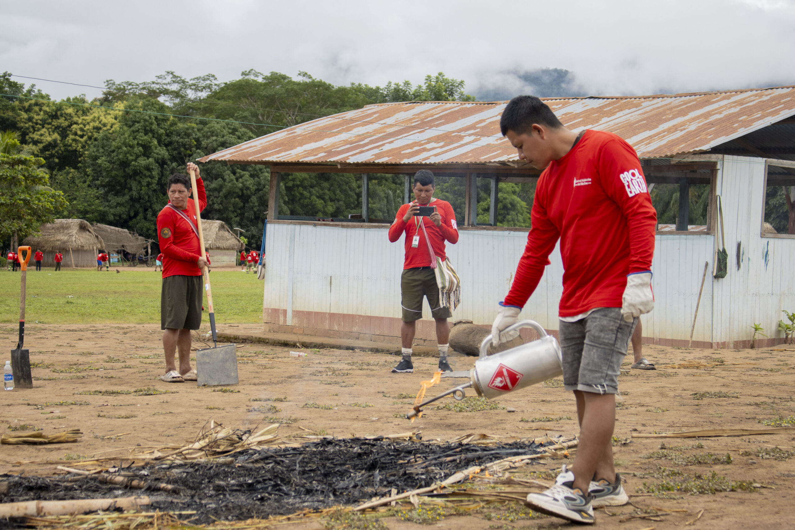 A PAAMARI brigade member ignites a controlled burn during a wildfire prevention training exercise.