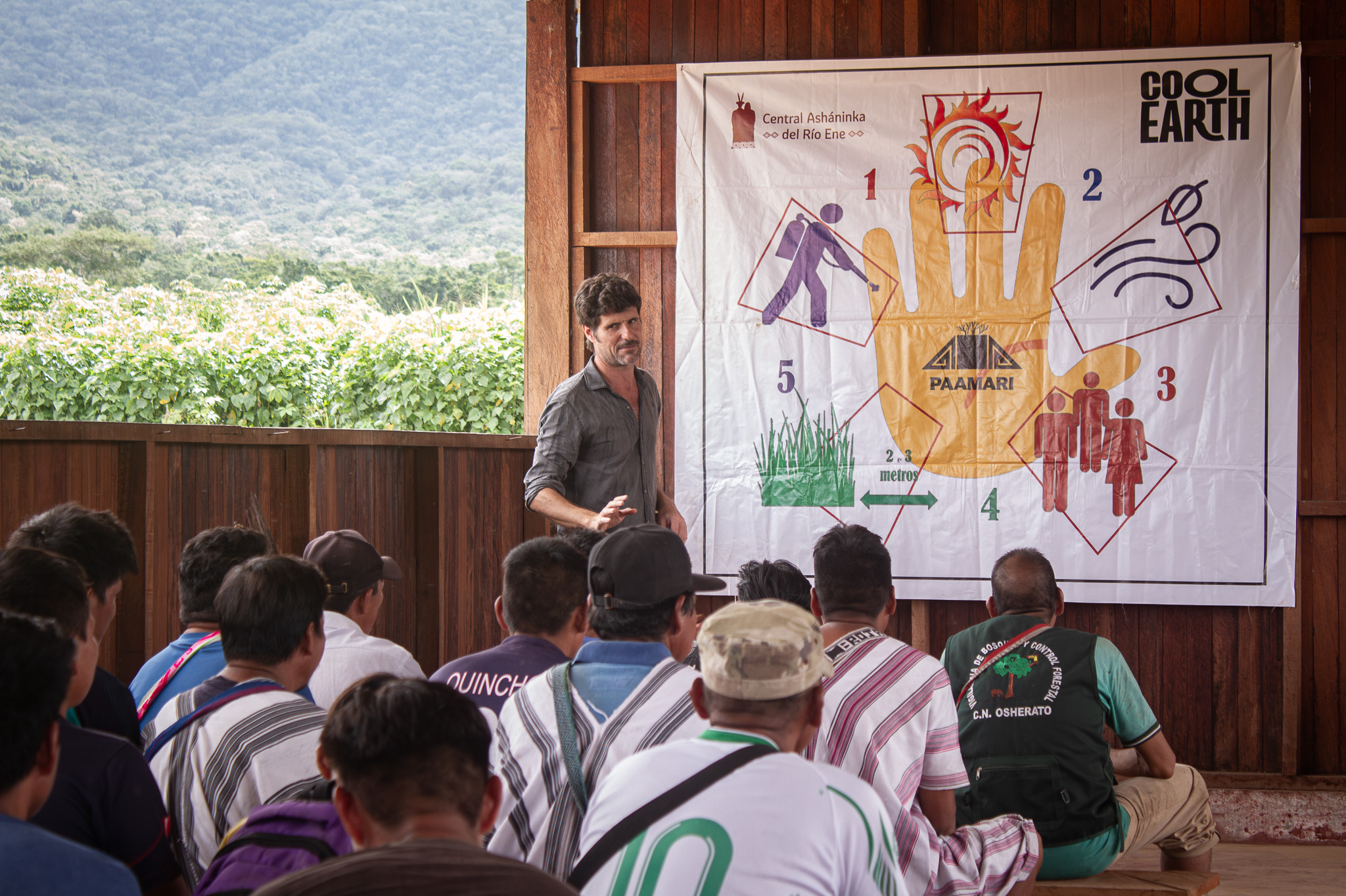 A trainer presents the PAAMARI Hand methodology to community members gathered for a fire management workshop.