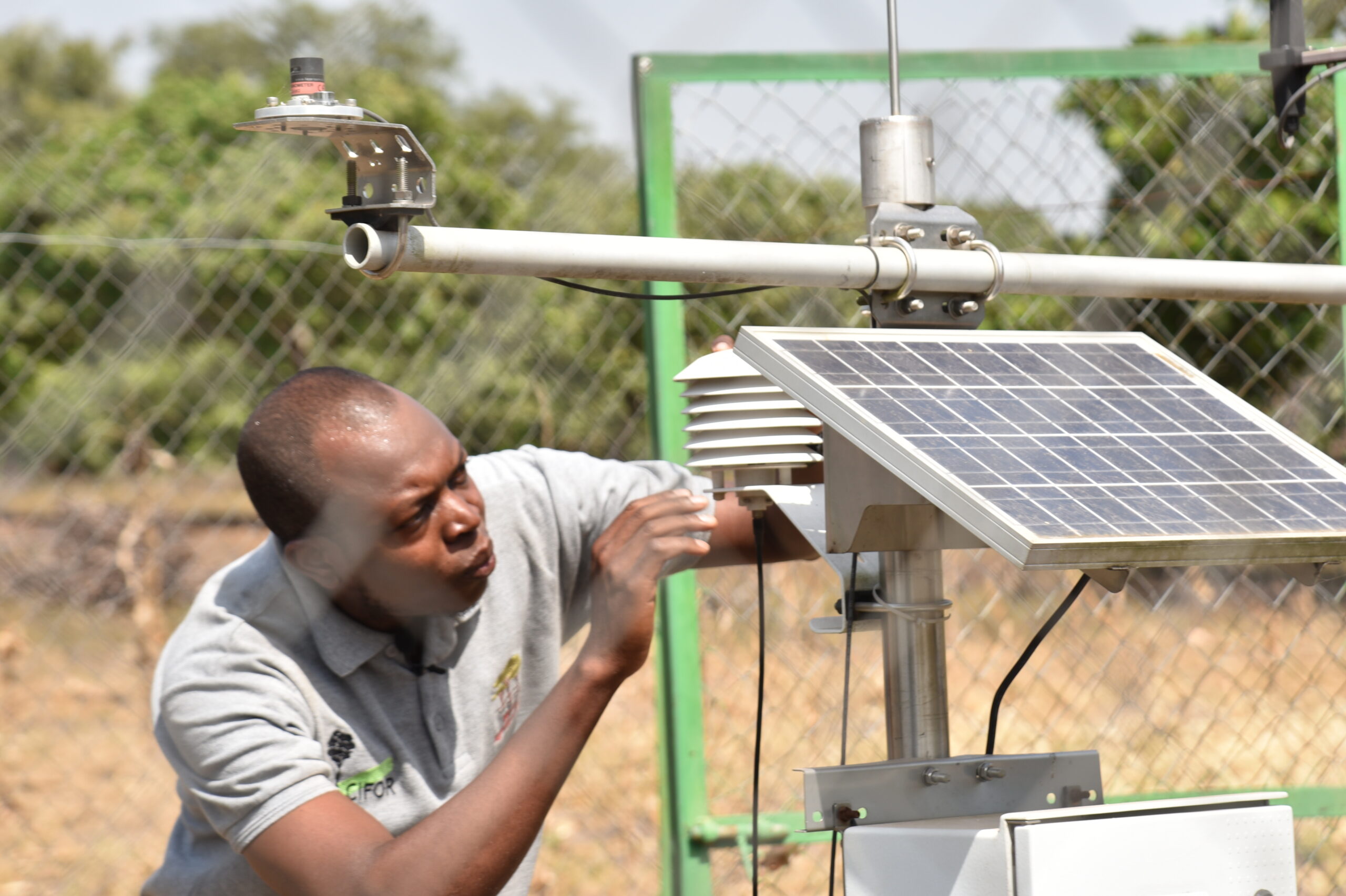A technician inspects a solar-powered agrometeorological station.