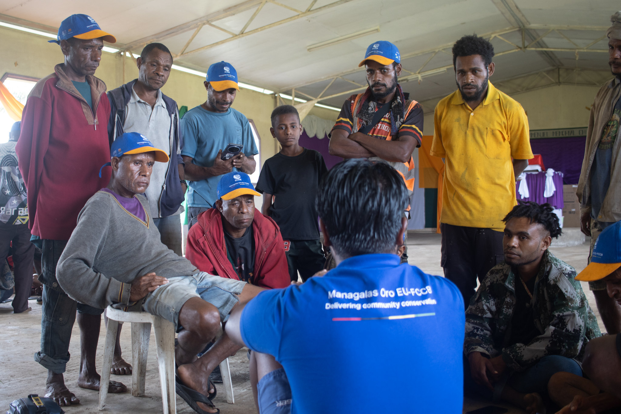 Participants gather in a small group during a social media workshop, discussing a practical storytelling exercise with a facilitator.