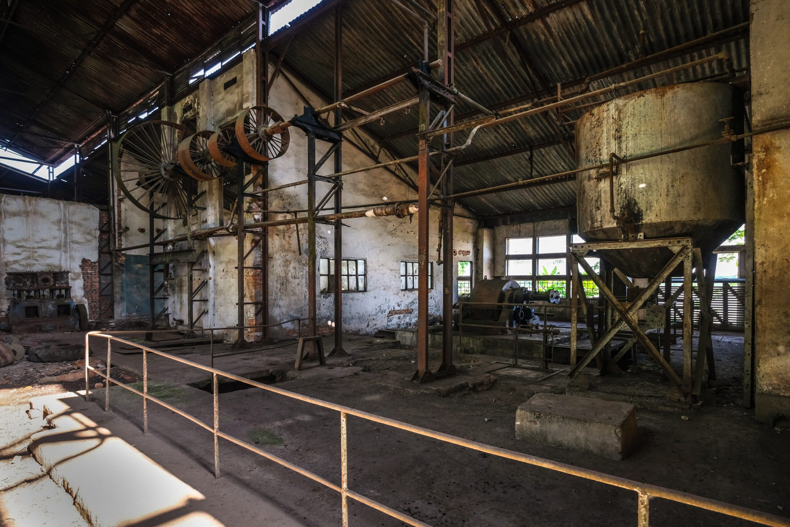 Interior of an abandoned palm oil refinery in Yangambi, with old processing equipment and structures visible.