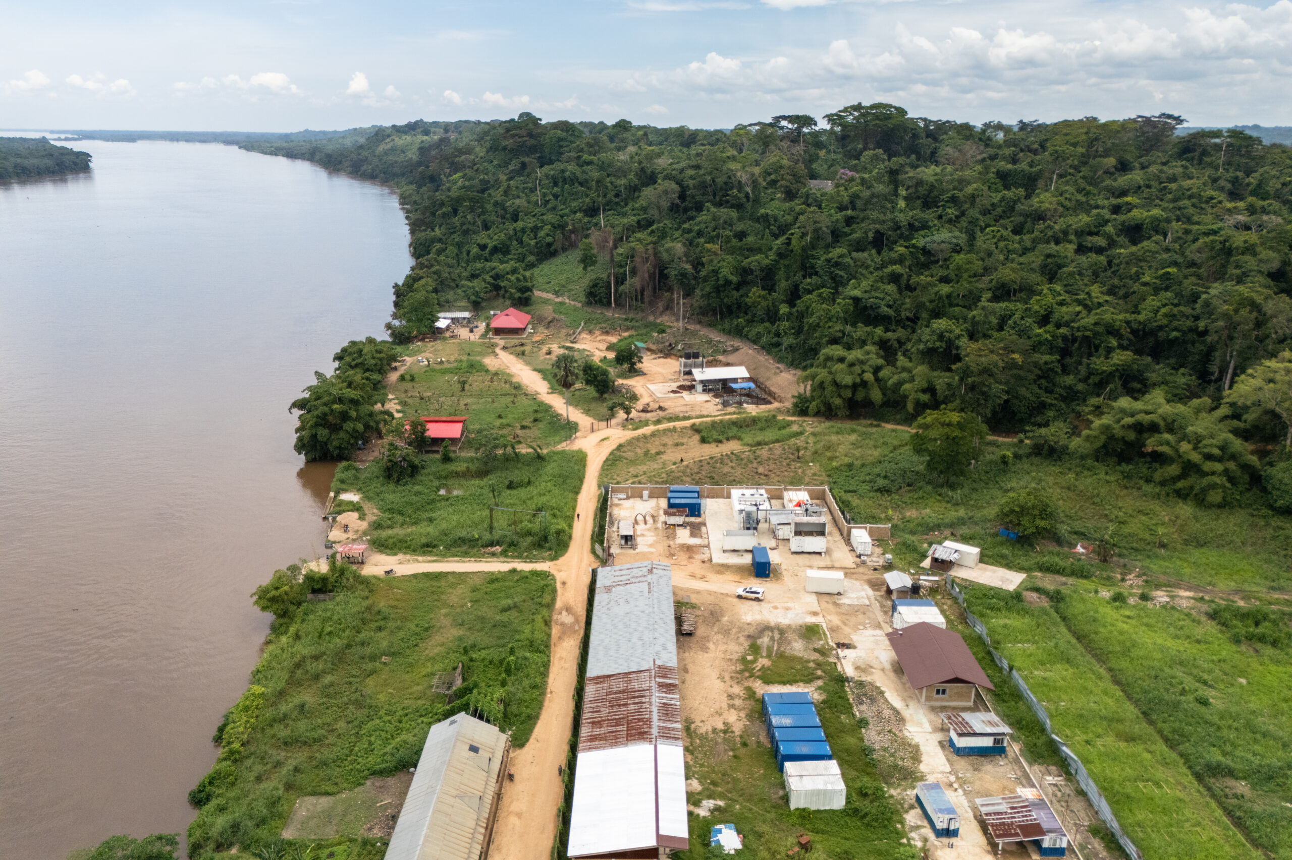 An aerial view of the palm oil mill and biomass cogeneration facility beside the river in Yangambi.