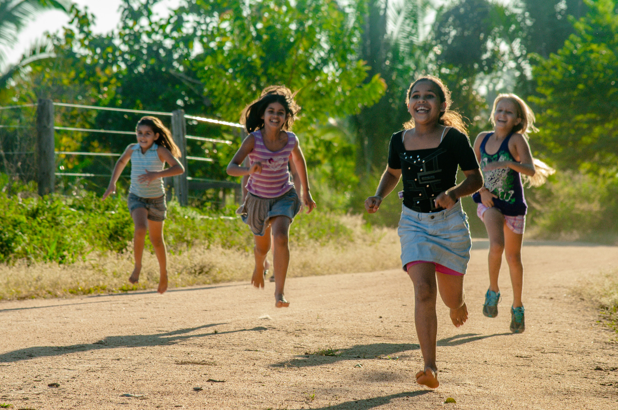 Children running along a rural road in Brazil, reflecting the joy and cultural connections that communities associate with forest landscapes. 