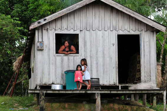 A family outside their home in the Brazilian Amazon, reflecting the central role of communities in understanding and shaping jurisdictional REDD+ initiatives.