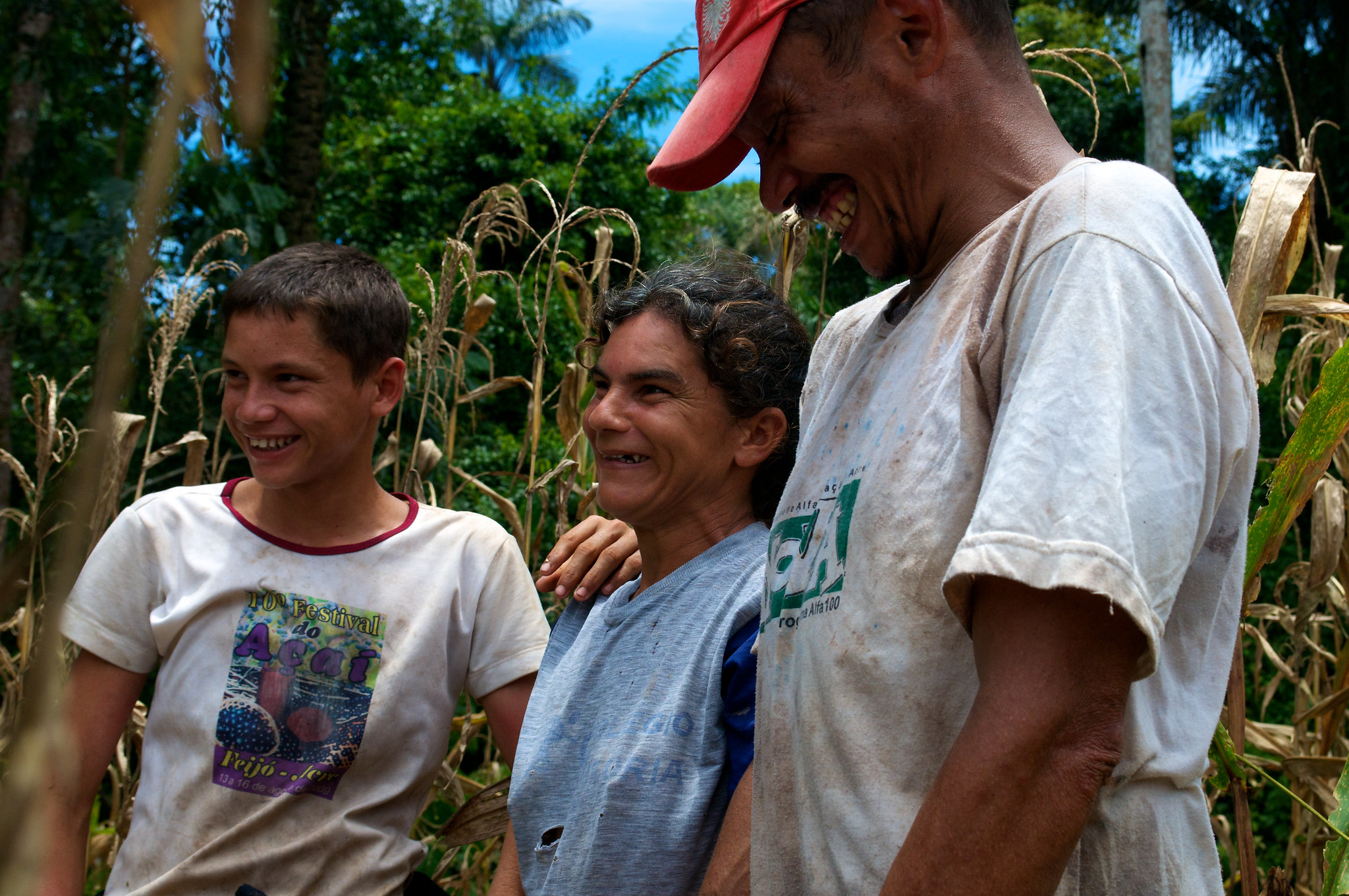 A family smiling together in a rural field in the Brazilian Amazon, reflecting the close ties between forests, food systems, culture and community wellbeing.
