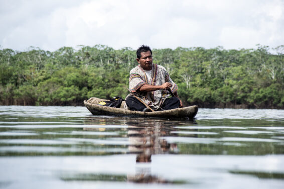 Man fishing from a small boat on a river in the Peruvian Amazon