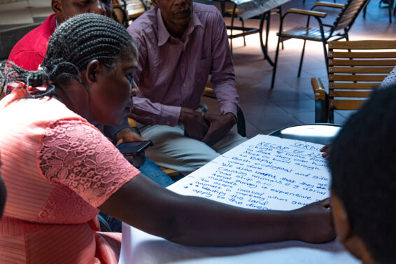Participant writing on a large sheet of paper during a cooperative training workshop in southern Zambia.