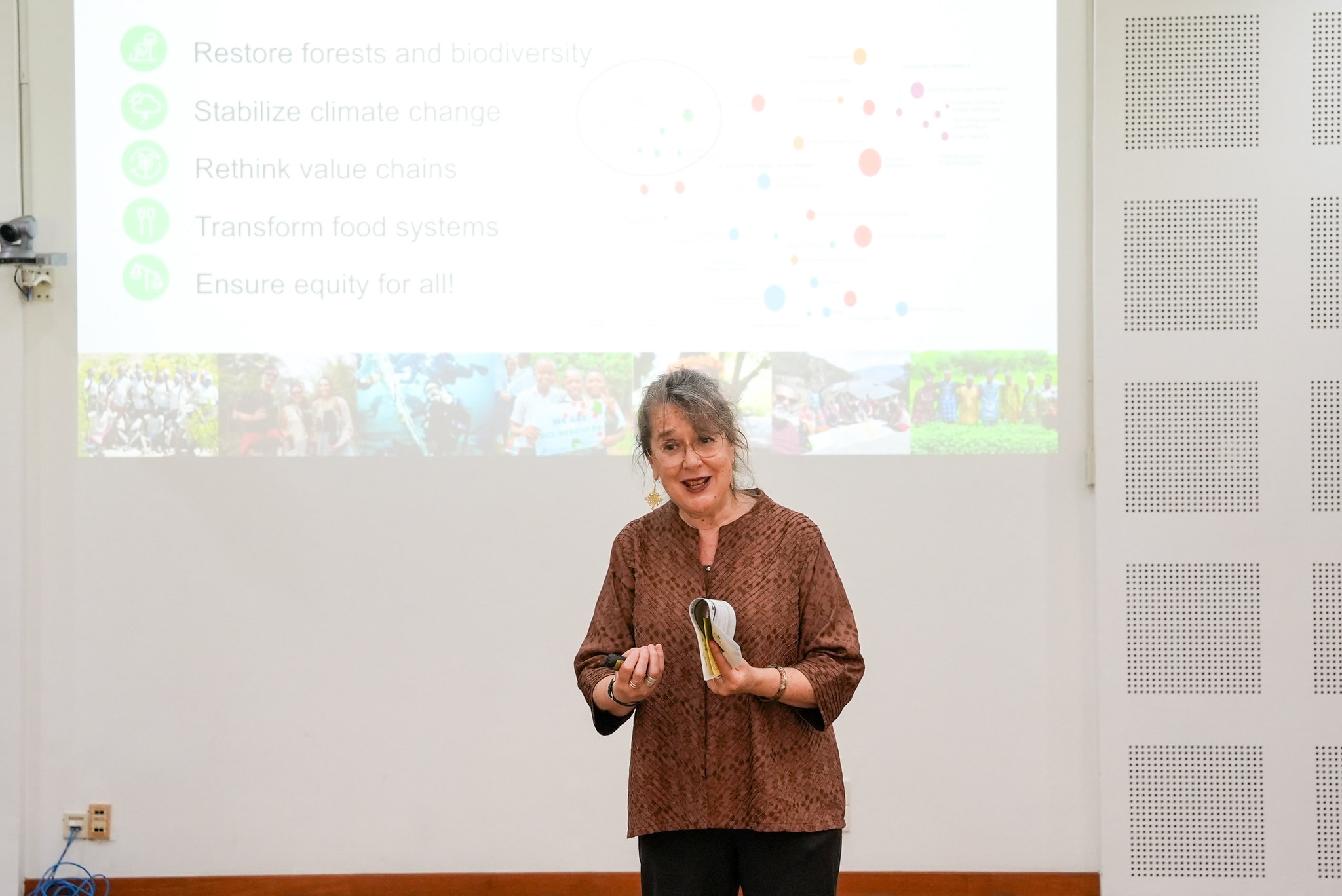 Cora speaking in front of a presentation slide during a restoration education workshop at CIFOR-ICRAF Bogor campus.