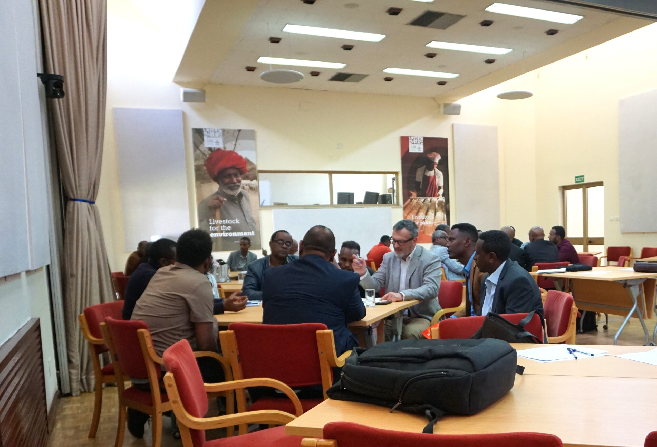 Small groups of participants sit around tables in discussion during a national workshop to validate Ethiopia’s National Agroecology Strategy in Addis Ababa.