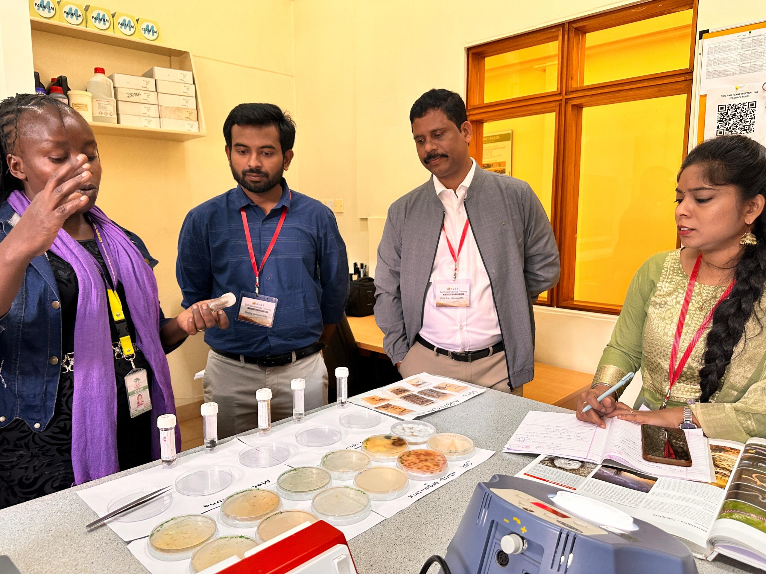 Group of trainees examining soil samples and learning laboratory analysis techniques during training in Kenya.