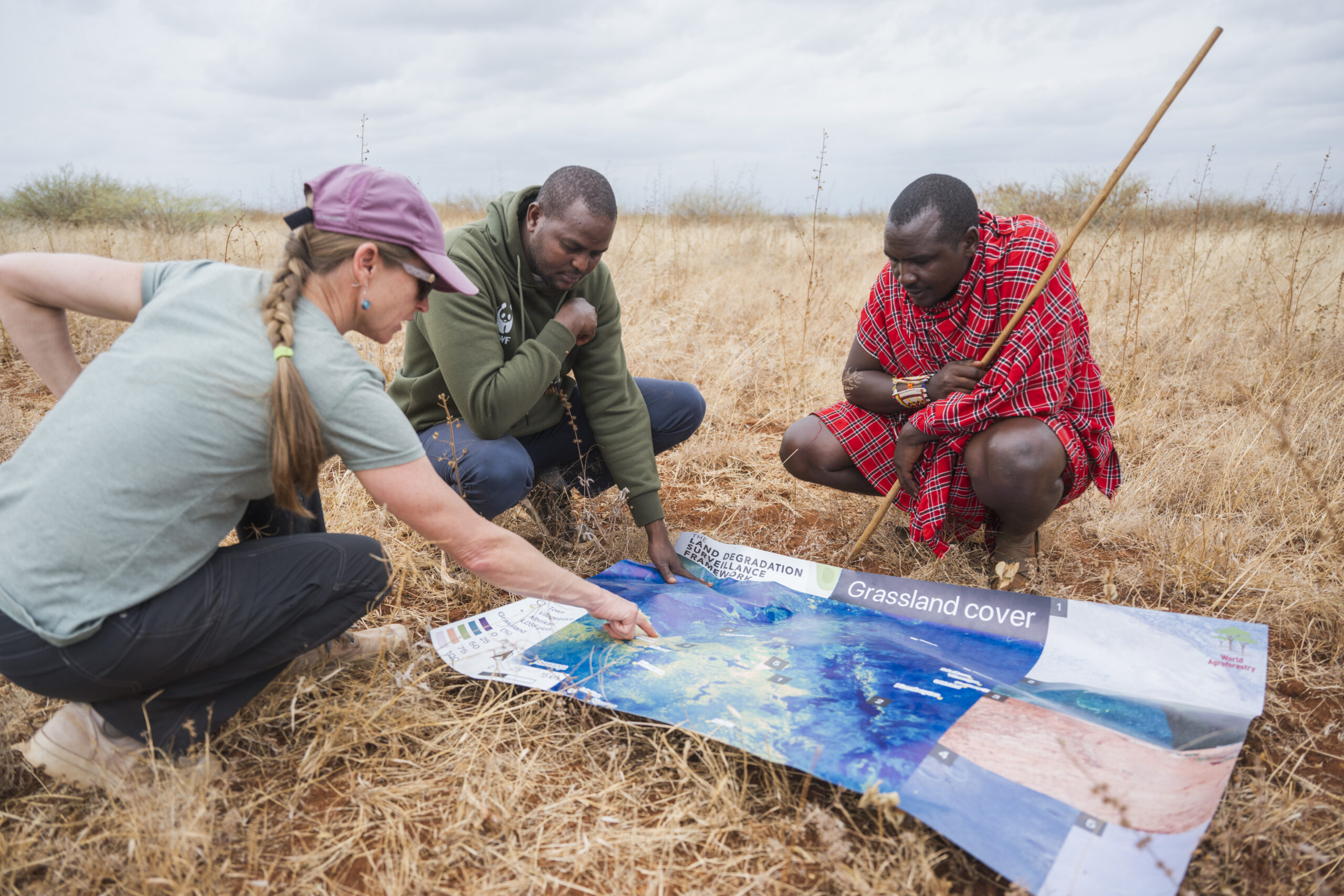 Researchers and a community member reviewing rangeland cover maps during soil and land health monitoring.