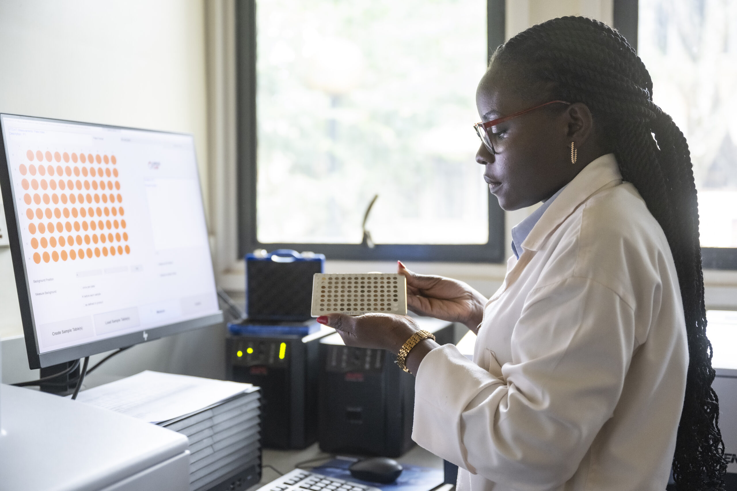 Scientist holding soil sample plate for spectroscopy analysis and soil mapping.