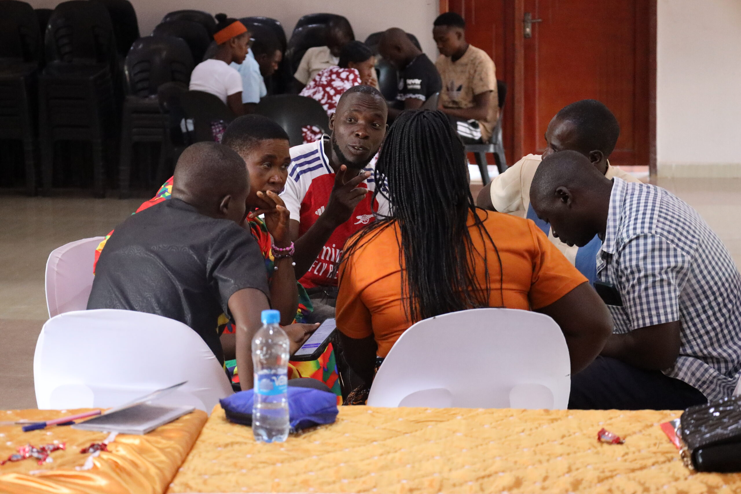 Participants discussing notes around a table during cooperative training.