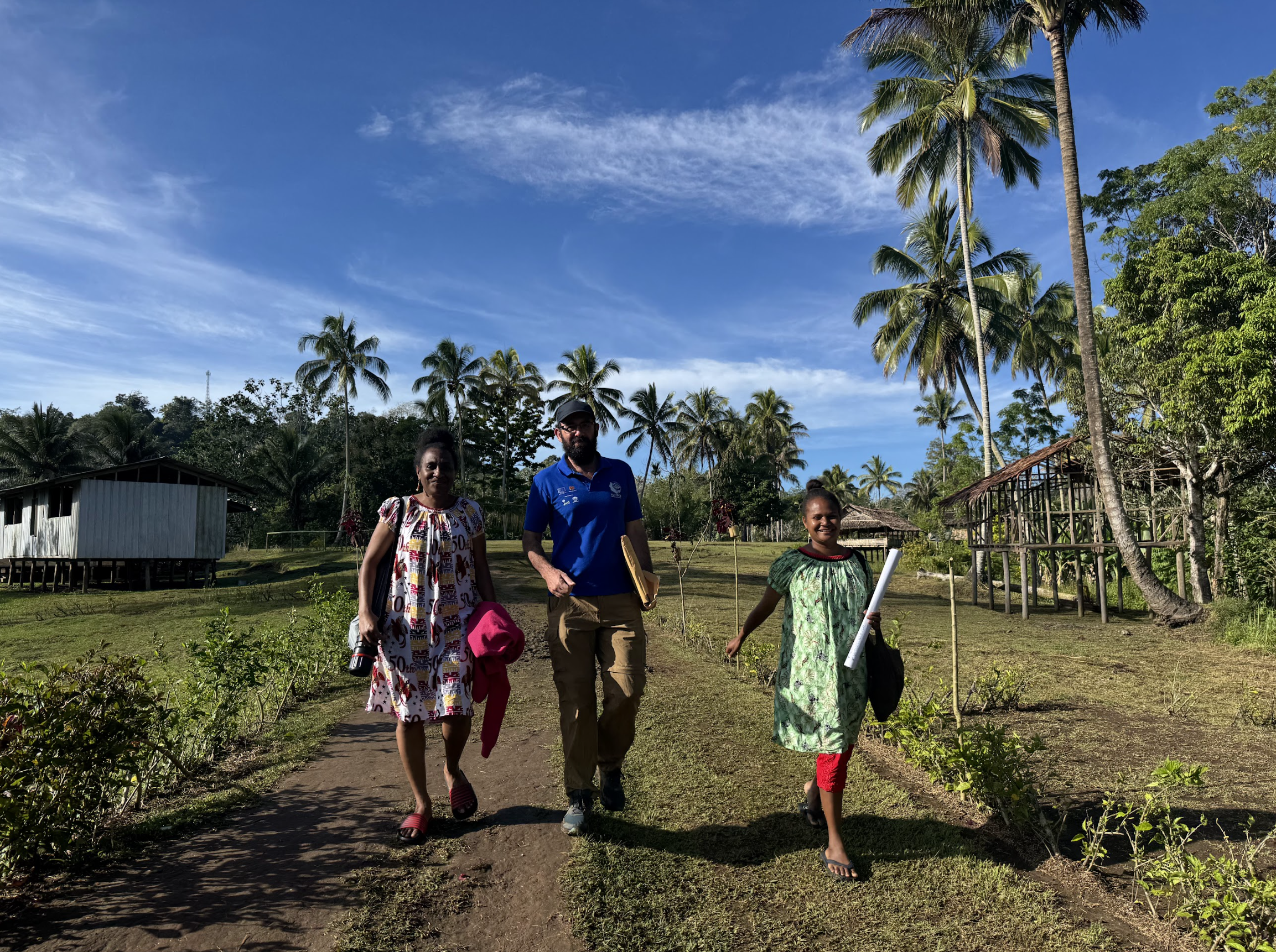 CIFOR-ICRAF staff and local community members walking together in Kawowogi Village on the Managalas Plateau in Papua New Guinea during the Combined Forum.