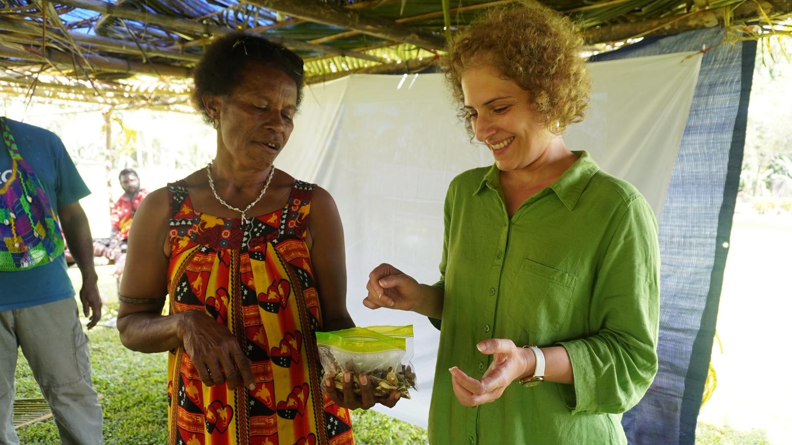Shahla Hosseini-Bai and a Kokoda community member examine processed okari nuts during a local workshop.